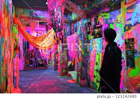 a man in a room with walls covered with colorful stickers 123142480
