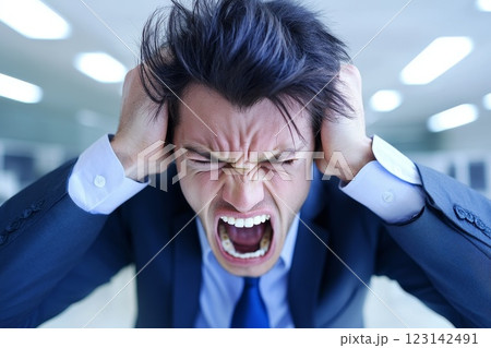 businessman brainstorming in empty office, he screams and clutches his head 123142491