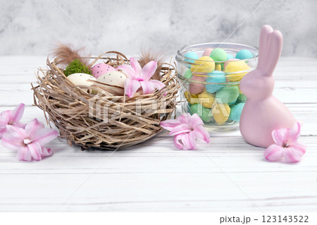 Easter composition with a nest, chocolate eggs and figurine of a bunny. 123143522