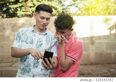 A young man explaining with his cell phone to a young man, A young man showing his cell phone to another young man 123143781