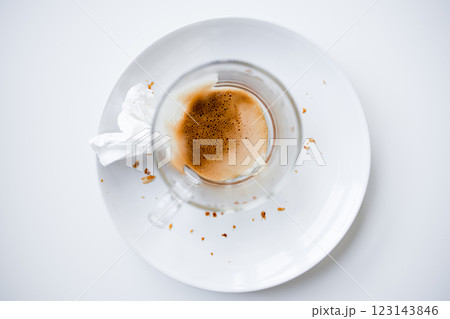 Empty cappuccino cup on white plate with crumbs and tissue Empty cappuccino cup on white plate with crumbs and tissue 123143846