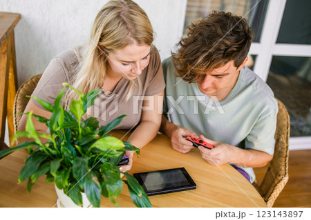 Joyful man and woman playing video games on terrace. Technology and game console concept Joyful man and woman playing video games on terrace. Technology and game console concept 123143897