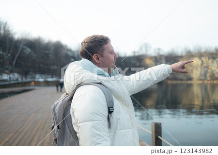 Travel and tourism. Portrait of young handsome man with backpack, walk in the woods while enjoying the nature landscape. High quality photo 123143982
