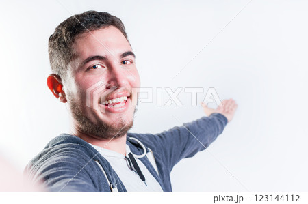 Happy young man welcoming you isolated. Portrait of smiling guy inviting to come 123144112