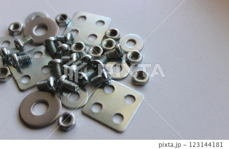 Pile Of Small Hardware On Clean White Surface At A Side Of Image. Stock Photo For Hardware Items Backgrounds Pile Of Small Hardware On Clean White Surface At A Side Of Image. Stock Photo For Hardware Items Backgrounds 123144181