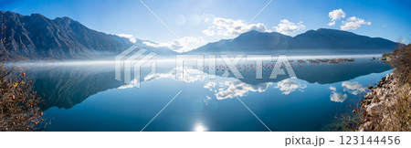 Mountains with clouds and their reflection in the still waters of the sea, separated by a strip of fog in winter morning Bay of Kotor in Montenegro Mountains with clouds and their reflection in the still waters of the sea, separated by a strip of fog in winter morning Bay of Kotor in Montenegro 123144456