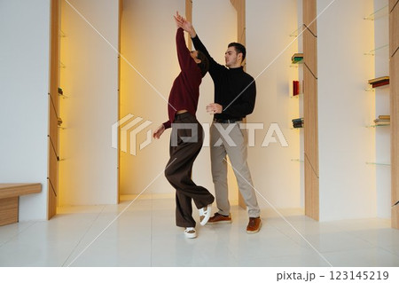 Couple dancing gracefully in a modern indoor space during daytime 123145219