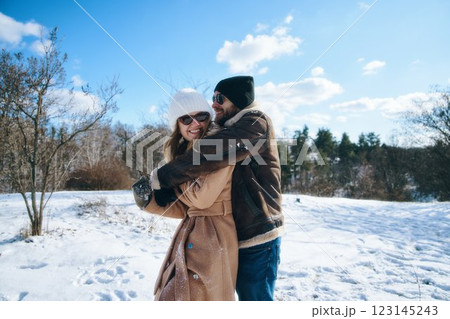 Couple enjoys a winter day together in a snowy landscape Couple enjoys a winter day together in a snowy landscape 123145243