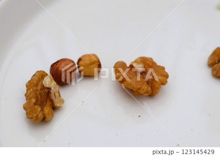 A Beautiful Variety of Different Nuts Presented on a Stylish White Plate for Enjoyment 123145429