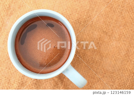 blue cup of coffee on brown surface 123146159