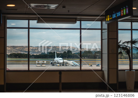 modern commercial plane waiting at airport terminal with mountain views in background, air travel and transportation concept 123146806