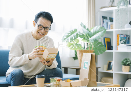 デリバリーで注文した料理を食べる男性 デリバリーで注文した料理を食べる男性 123147317