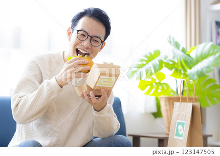 デリバリーで注文した料理を食べる男性 デリバリーで注文した料理を食べる男性 123147505