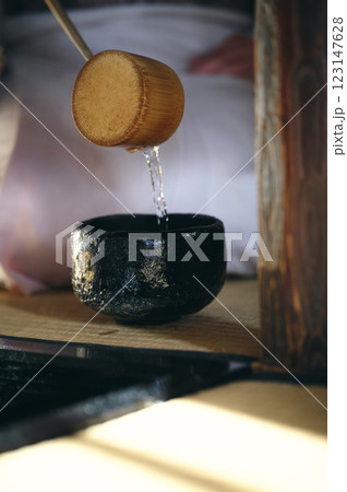 着物の女性が黒い茶碗にお湯を汲んでいる 着物の女性が黒い茶碗にお湯を汲んでいる 123147628