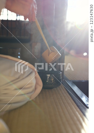 着物の女性が黒い茶碗にお湯を汲んでいる 123147630