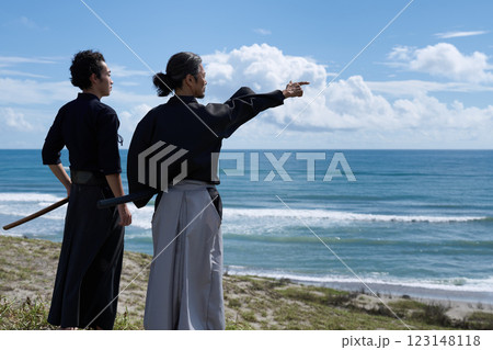 刀を携えて海を見つめる2人の男性の後ろ姿 123148118