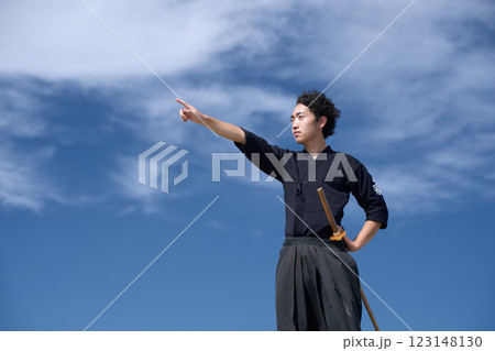 青空のもと遠くを指差す剣道着の男性 青空のもと遠くを指差す剣道着の男性 123148130