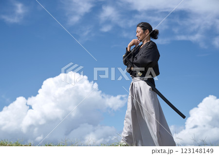 青空のもと考えごとをするサムライ 123148149