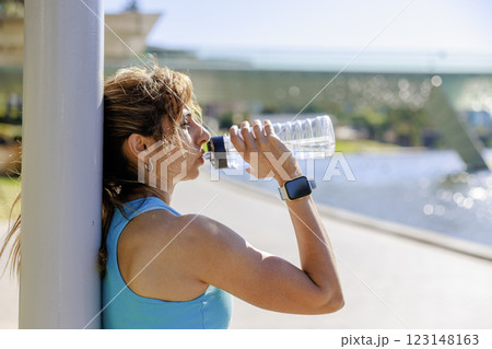 公園で水を飲むランニング終わりの女性 公園で水を飲むランニング終わりの女性 123148163
