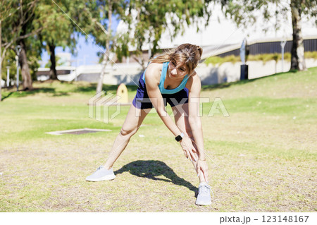 公園の芝生で全身のストレッチをする女性 公園の芝生で全身のストレッチをする女性 123148167