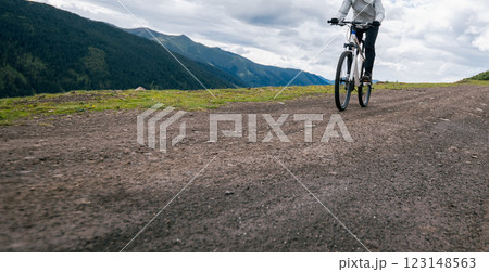 Riding mountain bike on grassland mountain top Riding mountain bike on grassland mountain top 123148563