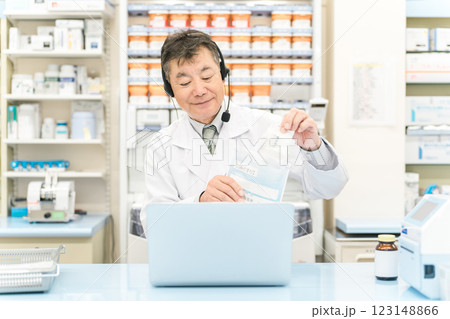 病院・薬局でパソコンを使ってオンライン服薬指導・診療する薬剤師・調剤師の男性(処方箋・医師) 病院・薬局でパソコンを使ってオンライン服薬指導・診療する薬剤師・調剤師の男性(処方箋・医師) 123148866