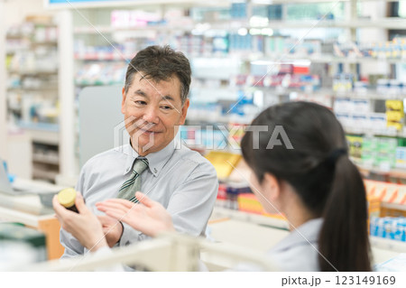 薬局で薬剤師から服薬指導を受けるシニア男性 123149169