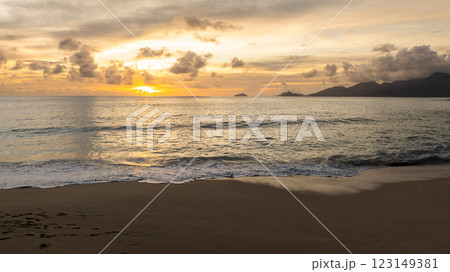 Sunset over calm ocean waves with gentle reflections on the wet sandy shore. Seychelles, Mahe. Sunset over calm ocean waves with gentle reflections on the wet sandy shore. Seychelles, Mahe. 123149381