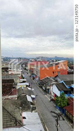 Tranquil view of a serene village with red-tiled roofs, surrounded by greenery, under a partly cloudy sky. Captures peaceful rural living and a connection to nature. 123149750