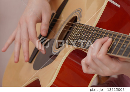 Woman guitarist is practicing of playing classical six string acoustic guitar 123150084