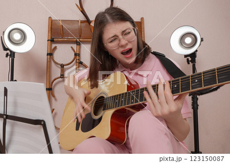 Woman plays acoustic guitar and sings song with so much emotion 123150087