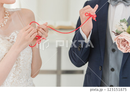 結婚式場で赤い糸で結ばれる新郎新婦（ブライダル・ウェディング） 123151875