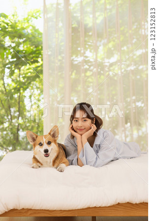 Side view of woman lying in bed with dog 123152813