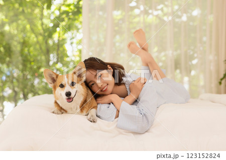 Side view of woman lying in bed with dog Side view of woman lying in bed with dog 123152824
