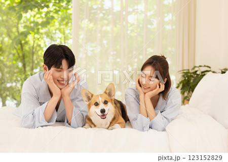 Portrait of young couple lying in bed with dog Portrait of young couple lying in bed with dog 123152829