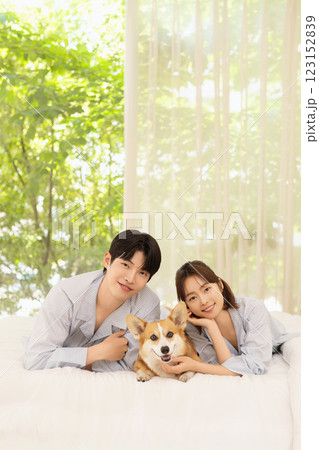 Portrait of young couple lying in bed with dog 123152839