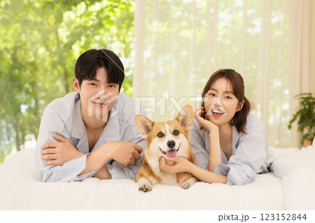 Portrait of young couple lying in bed with dog Portrait of young couple lying in bed with dog 123152844