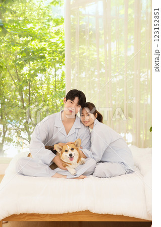 Cropped view of young couple sitting on bed with dog 123152851