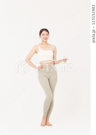 Cropped view of young woman measuring waist circumference wearing sportswear 123152983