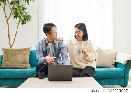 パソコンのモニターを見ながら話し合う夫婦 パソコンのモニターを見ながら話し合う夫婦 123153027