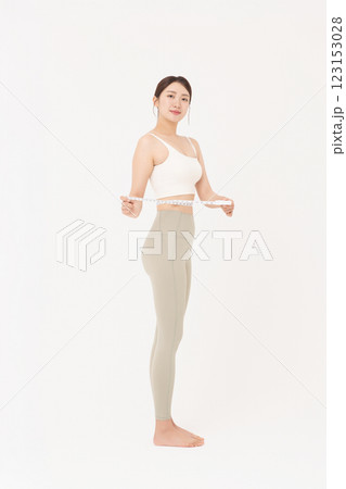 Cropped view of young woman measuring waist circumference wearing sportswear Cropped view of young woman measuring waist circumference wearing sportswear 123153028
