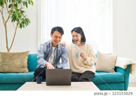 パソコンのモニターを見ながら話し合う夫婦 123153029