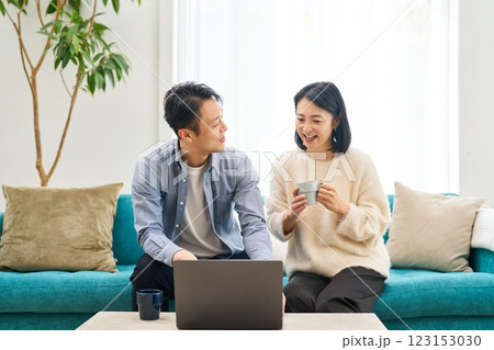パソコンのモニターを見ながら話し合う夫婦 123153030