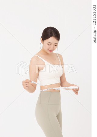 Cropped view of young woman measuring waist circumference wearing sportswear 123153033