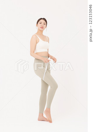 Cropped view of young woman wearing sportswear measuring leg circumference Cropped view of young woman wearing sportswear measuring leg circumference 123153046