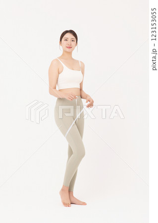 Cropped view of young woman wearing sportswear measuring leg circumference Cropped view of young woman wearing sportswear measuring leg circumference 123153055
