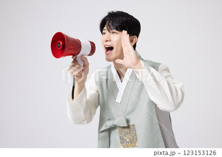 A young man wearing a hanbok and shouting while holding a megaphone 123153126