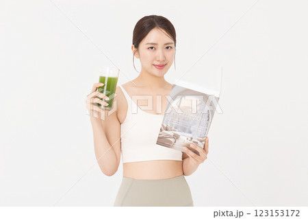 Portrait of young woman wearing sportswear, drinking healthy drink and reading book Portrait of young woman wearing sportswear, drinking healthy drink and reading book 123153172
