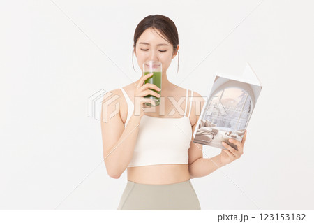 Portrait of young woman wearing sportswear, drinking healthy drink and reading book Portrait of young woman wearing sportswear, drinking healthy drink and reading book 123153182