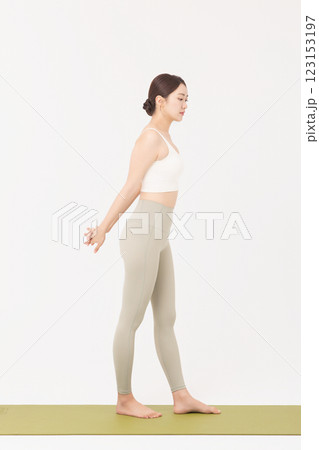 Portrait of a young woman wearing sportswear and stretching on a yoga mat Portrait of a young woman wearing sportswear and stretching on a yoga mat 123153197